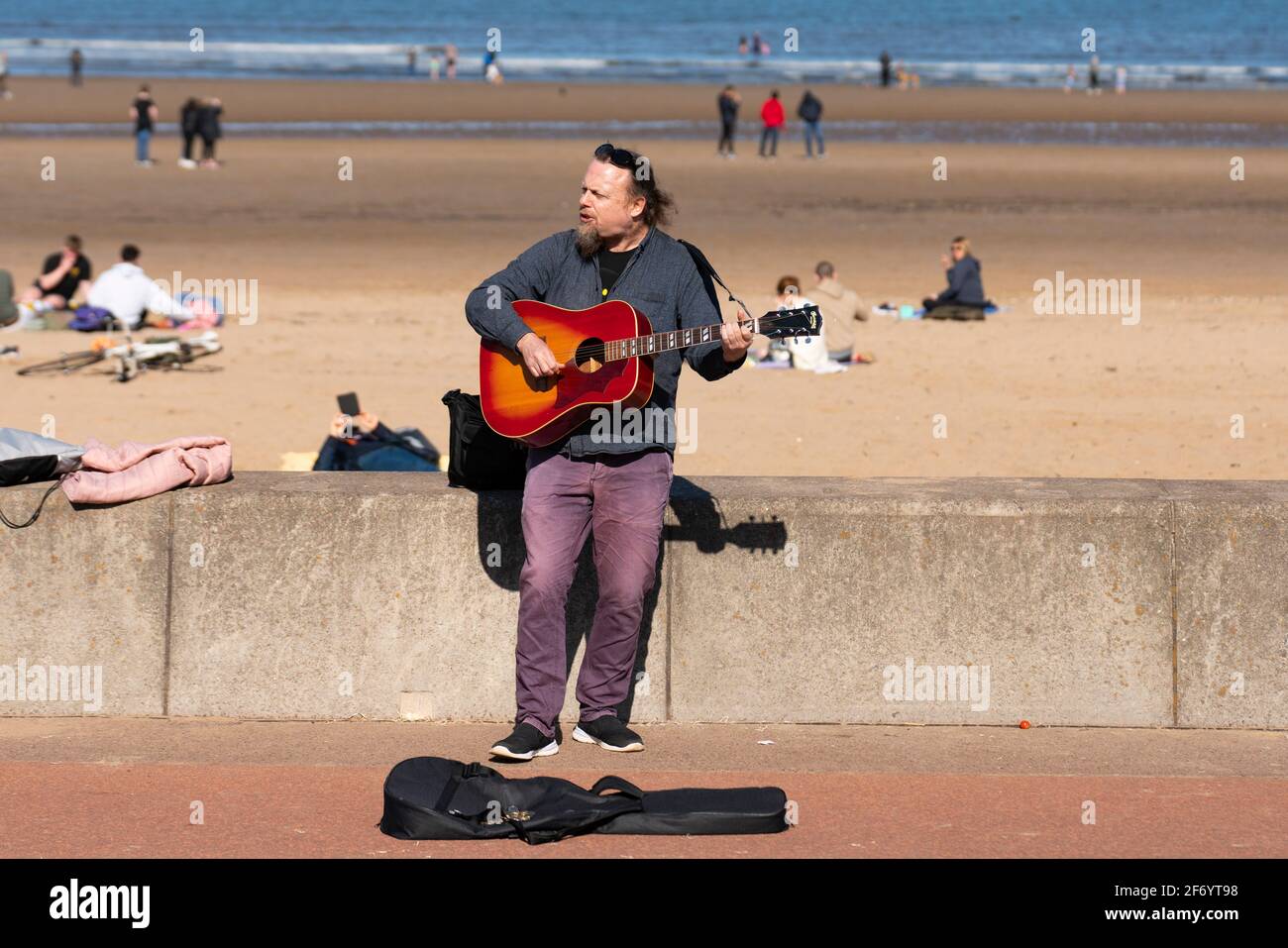 Portobello, Scotland, UK. 3 April 2021. Easter weekend crowds descend on Portobello beach and promenade to make the most of newly relaxed  Covid-19 lockdown travel restrictions and warm sunshine with uninterrupted blue skies. Pic;  Buskers have returned. Iain Masterton/Alamy Live News Stock Photo