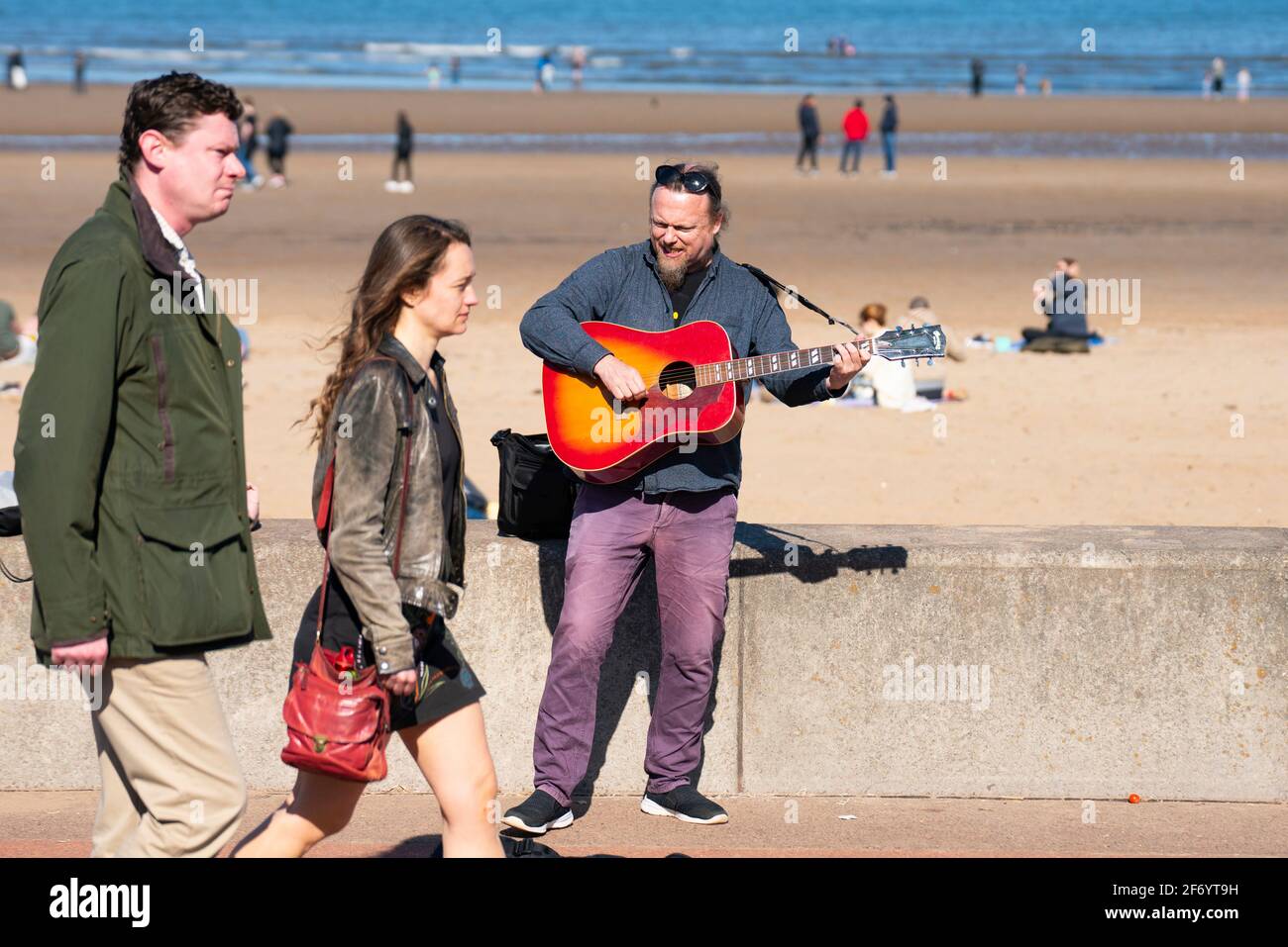 Portobello, Scotland, UK. 3 April 2021. Easter weekend crowds descend on Portobello beach and promenade to make the most of newly relaxed  Covid-19 lockdown travel restrictions and warm sunshine with uninterrupted blue skies. Pic;  Buskers have returned. Iain Masterton/Alamy Live News Stock Photo