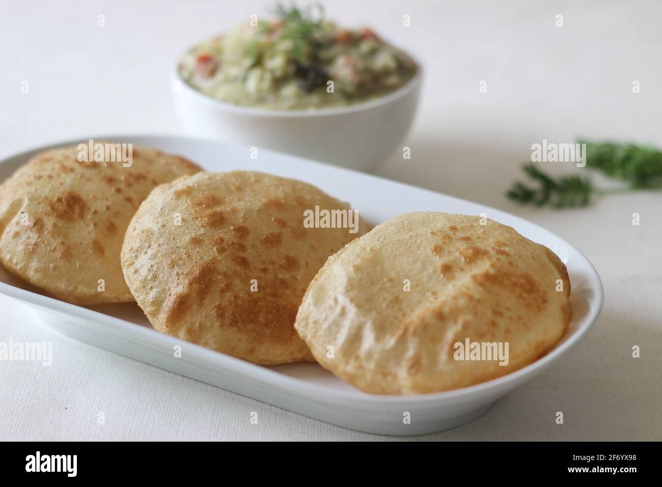 Deep fried indian flat bread served with mixed vegetable curry in a