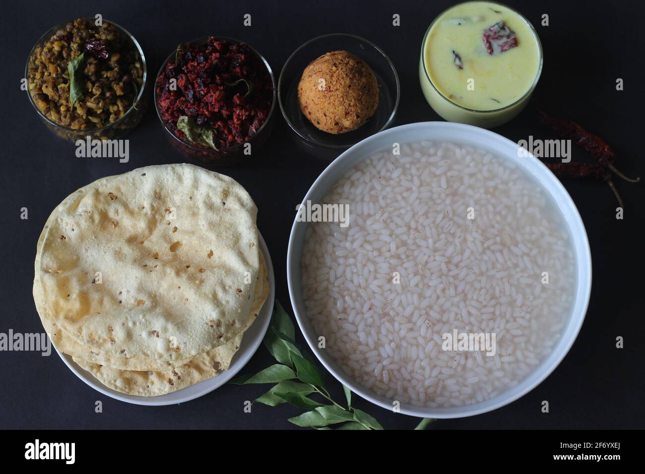 Rice porridge or Kanji along with Coconut chutney, Beetroot potato thoran, stir fried moong, Fried papad and Tempered buttermilk. A favourite meal of Stock Photo