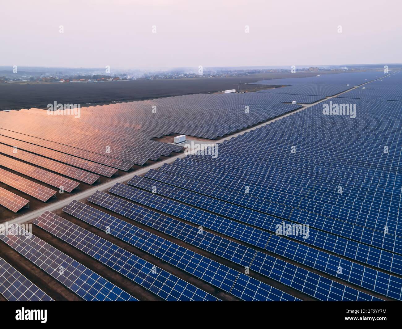 Aerial drone view of large solar panels at a solar farm at bright