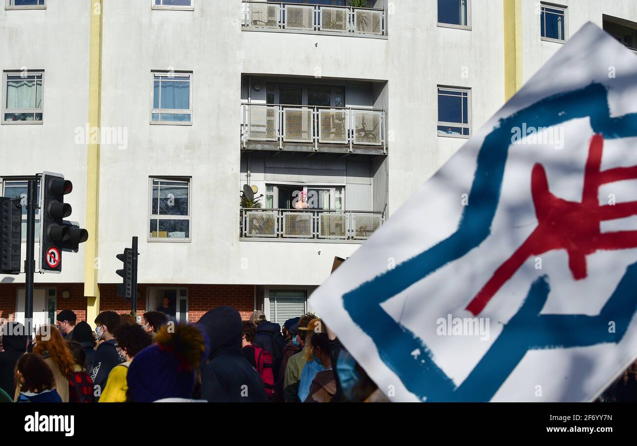 Brighton UK 3rd April 2021 - Residents watch from balconies as hundreds of "Kill The Bill" protesters march through Brighton in protest against the governments controversial new bill which would give police powers to crack down on peaceful protest : Credit Simon Dack / Alamy Live News Stock Photo