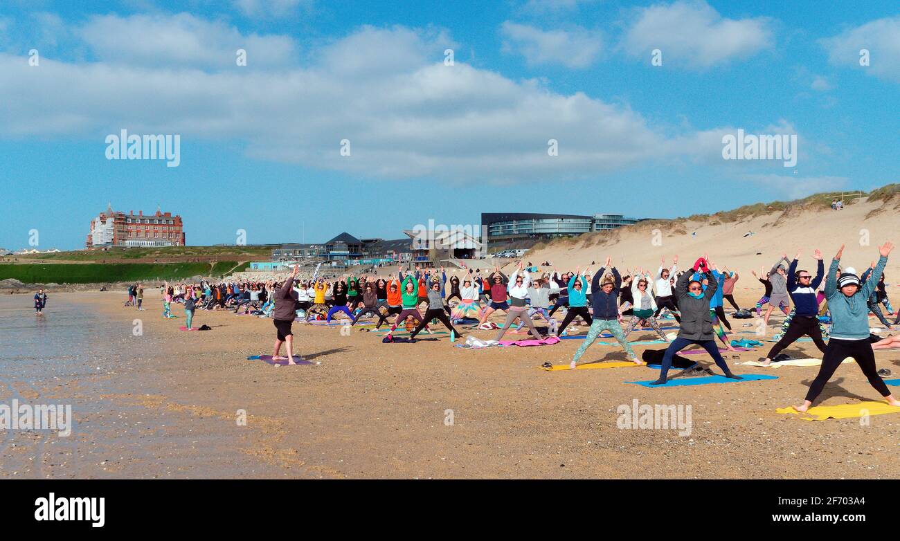 Newquay, Cornwall, England, 3rd  April 2021. UK weather: Cool with sunshine for a mass Yoga class involving 300 plus participants. Silent disco yoga organised by Anthony Durkin DJ in combination with Oceanflow yoga. Fistral beach. Credit: Robert Taylor/Alamy Live News� Stock Photo