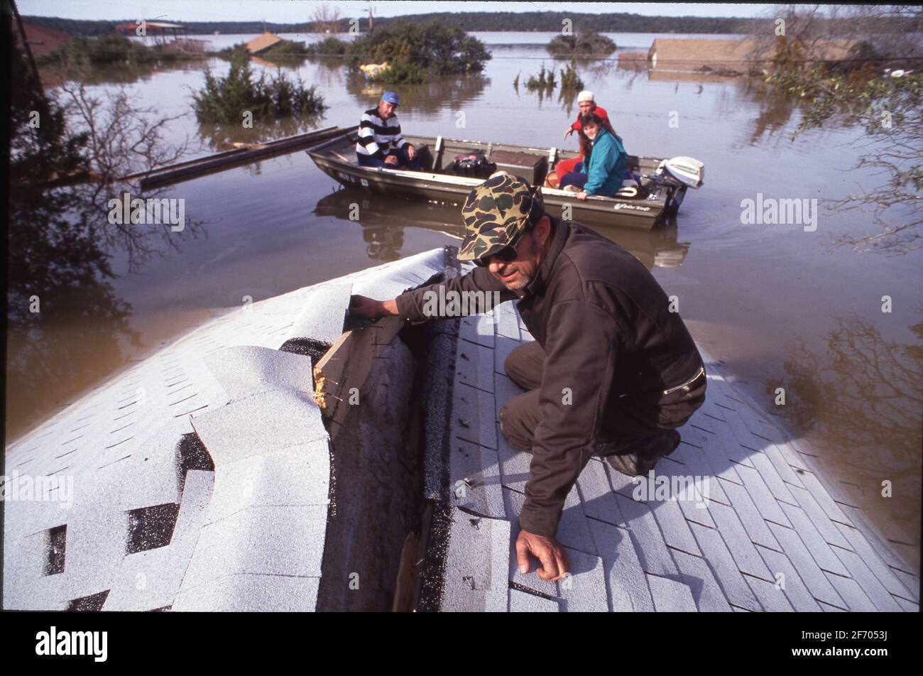 Residents of the waterfront Graveyard Point neighborhood on Lake Travis near Austin Texas look at damage to their submerged house after heavy rains raised the lake to historic high levels. ©Bob Daemmrich Stock Photo