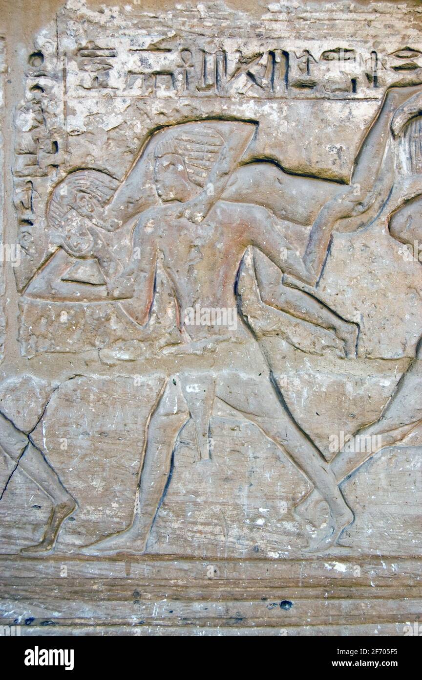 An ancient carving showing two men wrestling in a form of judo. This hieroglyphic carving is thousands of years old, on a wall of the temple of Medine Stock Photo