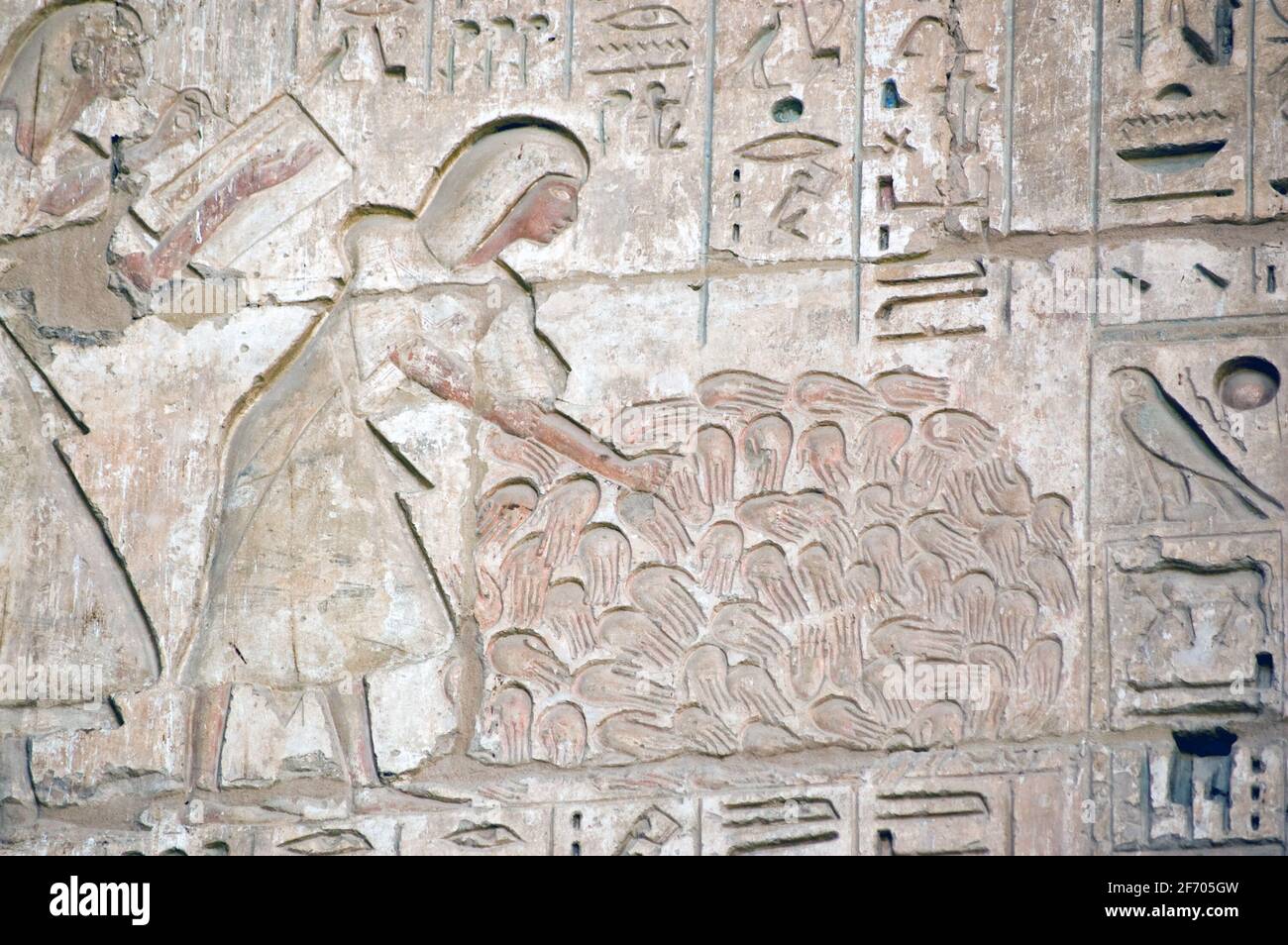 An ancient Egyptian carving showing scribes counting the hands of women killed in battle by the forces of Pharoah Ramses II. Temple of Medinet Habu on Stock Photo