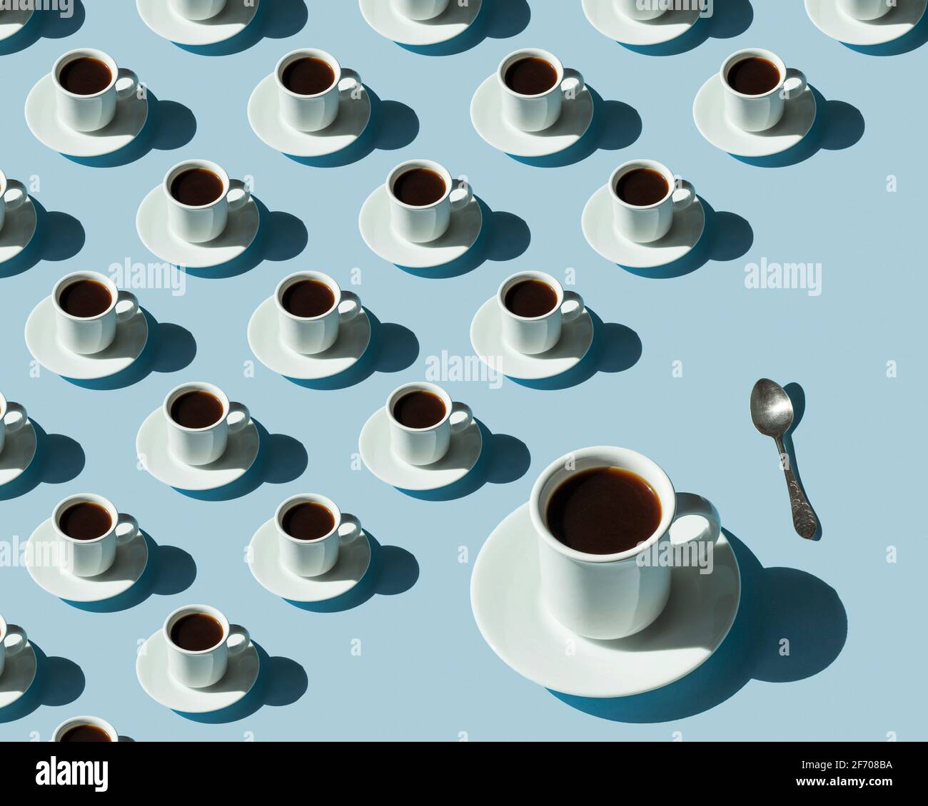 Rhythmic pattern from cups with coffee on a blue background. Stock Photo