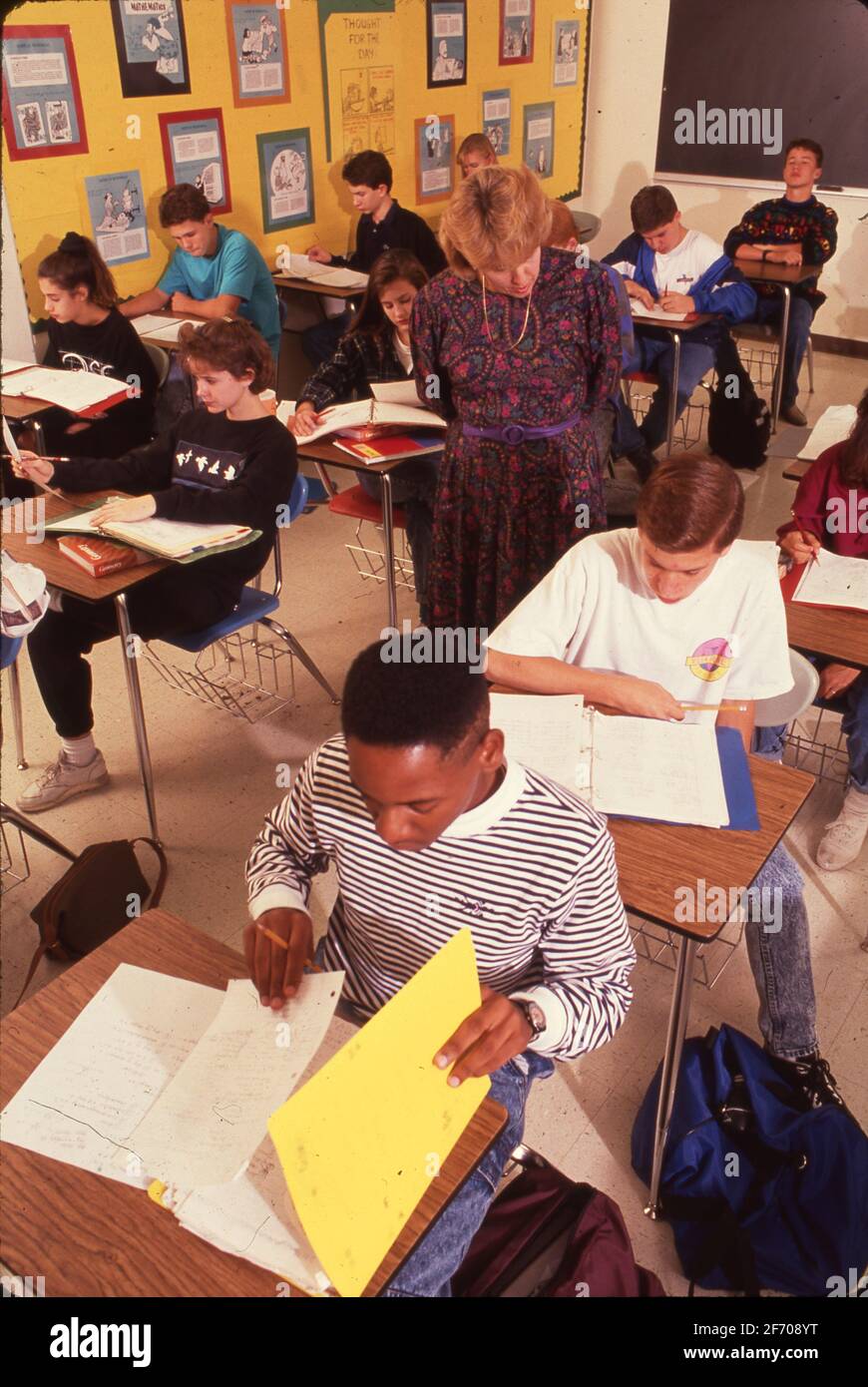 High school students work on assignment in math class while female teacher monitors their work. ©Bob Daemmrich Stock Photo