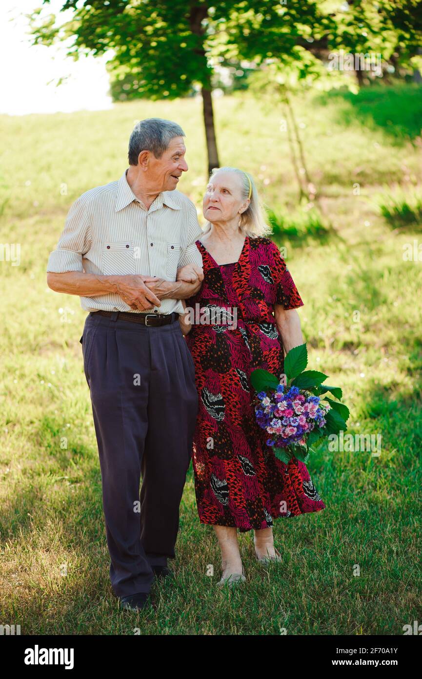 Age couple in love holding hands on a walk in the park in summer Stock ...