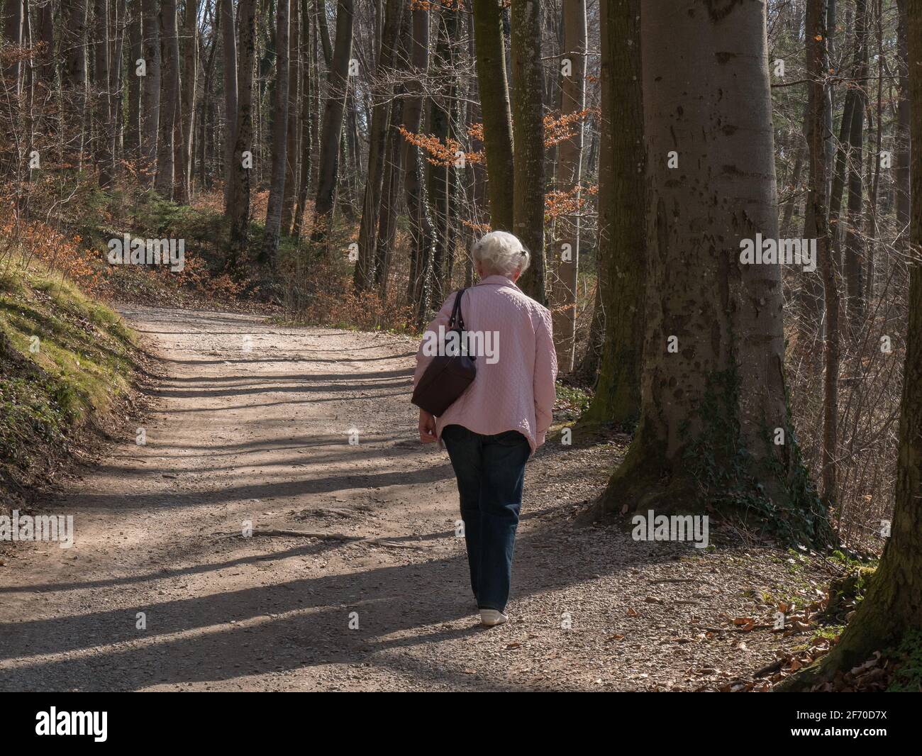 Senior woman sitting alone on park bench Stock Photo - Alamy