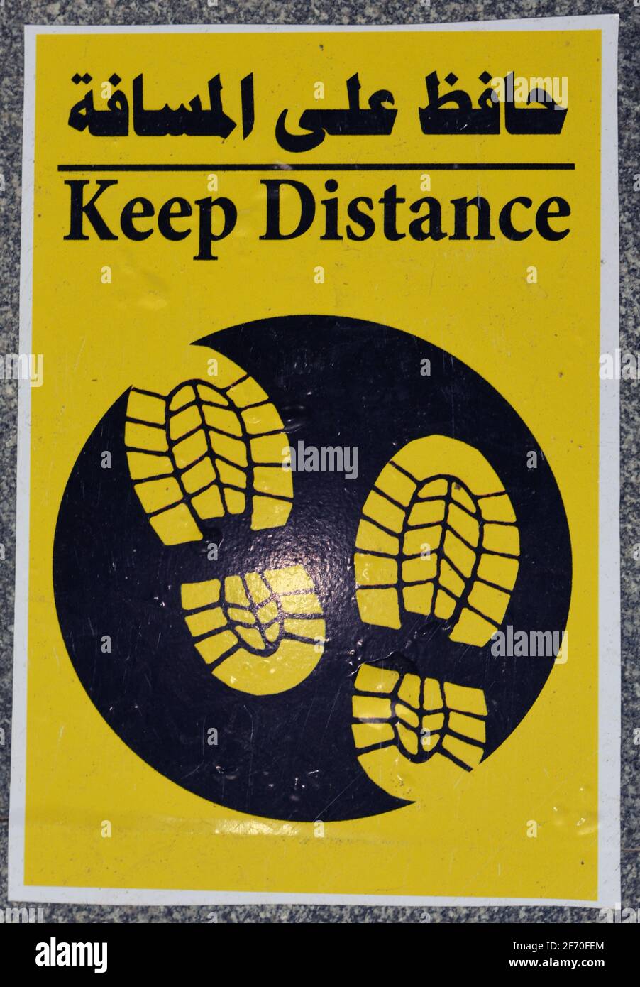 A Floor Sign In Arabic And English That Puts A Mark Where To Stand To A Floor Sign In Arabic And English That Puts A Mark Where To Stand To