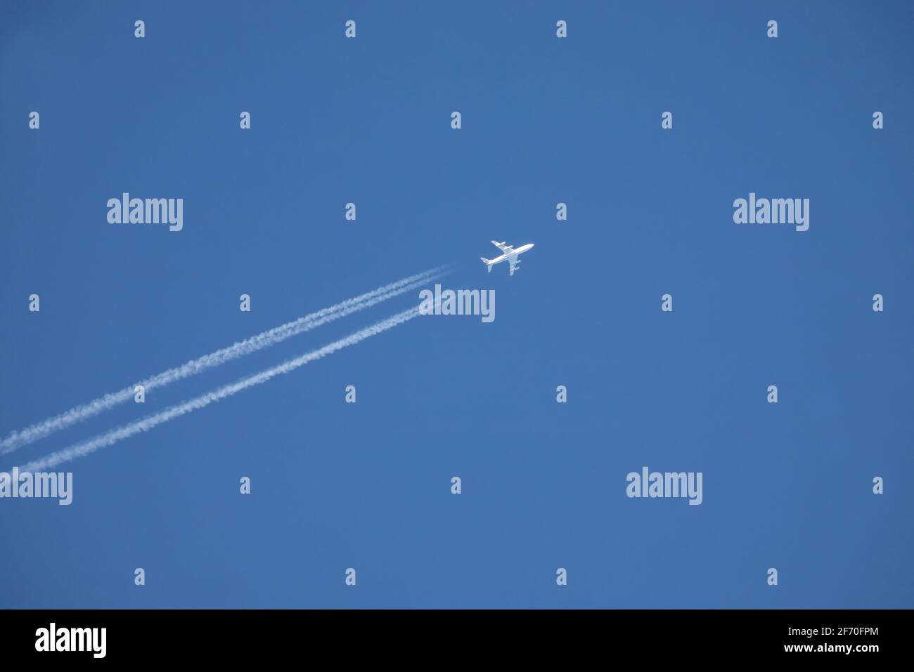 white jet airplane flying high in the blue sky Stock Photo - Alamy