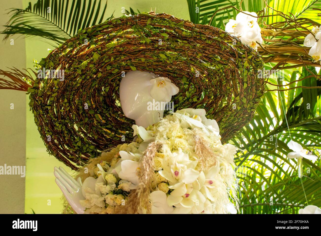 elegant mannequin decorating the garden dressed in white orchids and green leaves welcoming spring Stock Photo