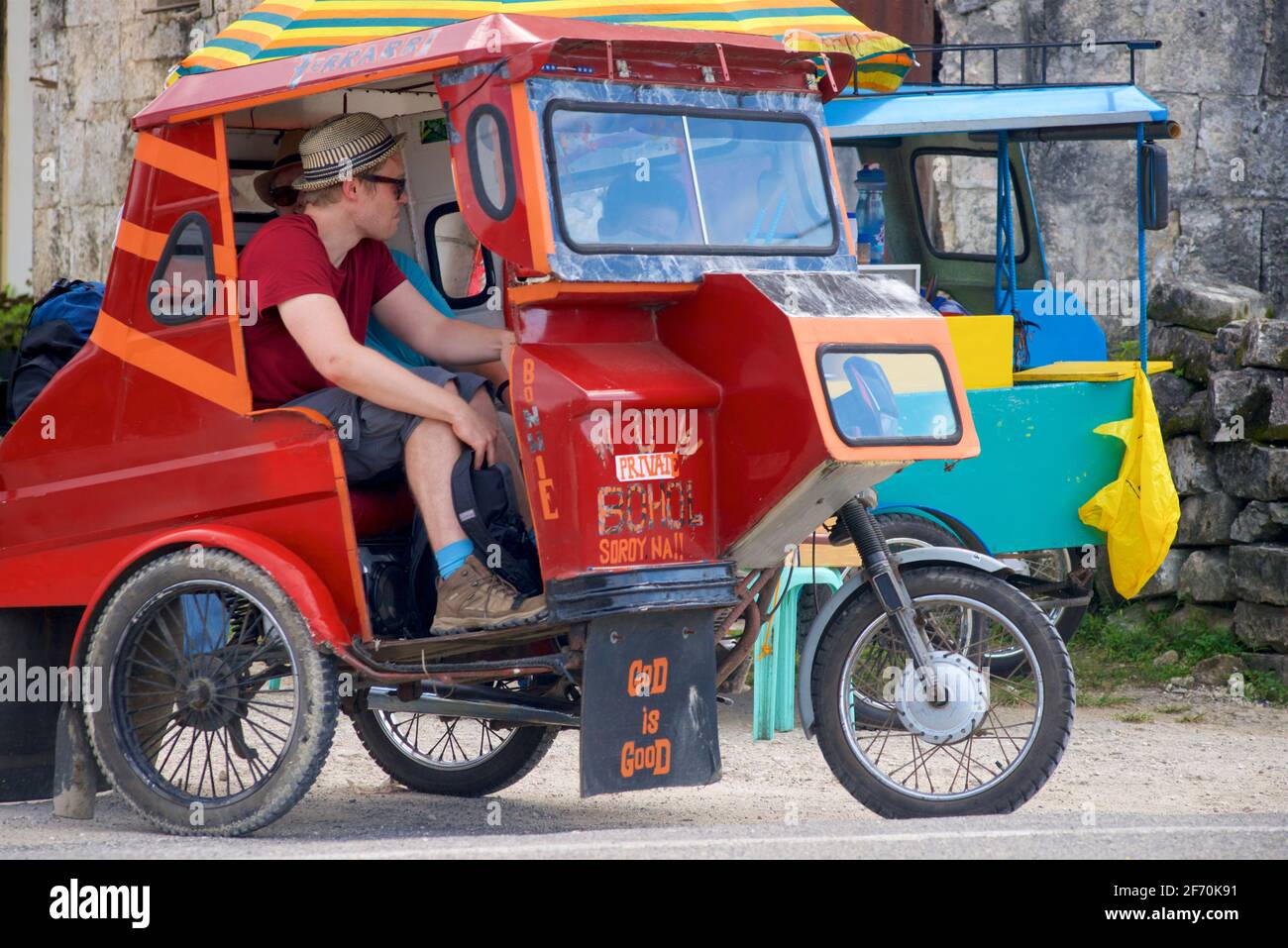 Western traveller in a motorised tuk-tuk like tricycle, Loboc, Bohol, Central Visayas, Philippines. Stock Photo
