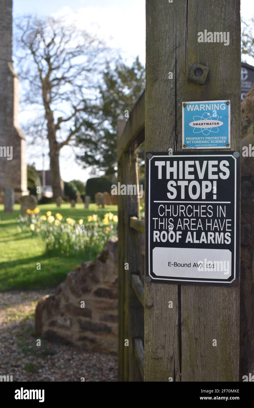 A sign warning that the church roof has an alarm. Stock Photo