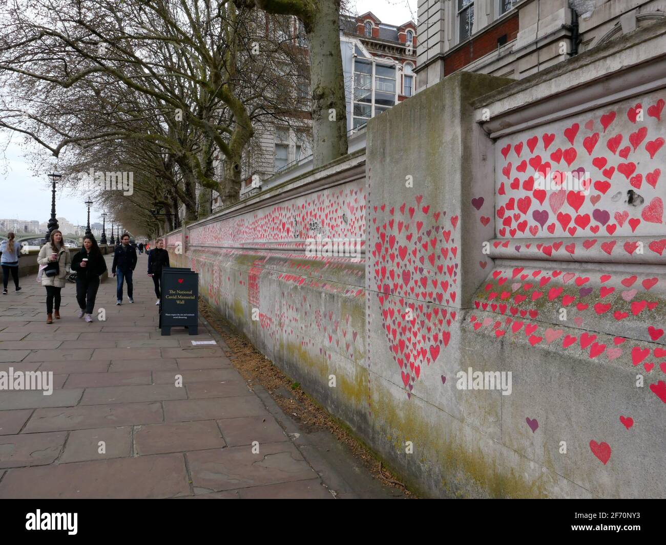 ‘An outpouring of love’ – enormous Covid-19 Memorial Wall begun opposite Parliament London, Monday 29 March– Bereaved families have today begun the creation of a vastCovid-19 Memorial Wall, on the Embankment opposite the Houses of Parliament in Westminster, London.Painting individual red hearts for each of the more than 145,000 lives lost to the virus, the group hopes to put personal stories at the heart of the Government’s approach to learning lessons from  the pandemic and expects the wall to stretch to  over half a kilometre in the coming days. Stock Photo