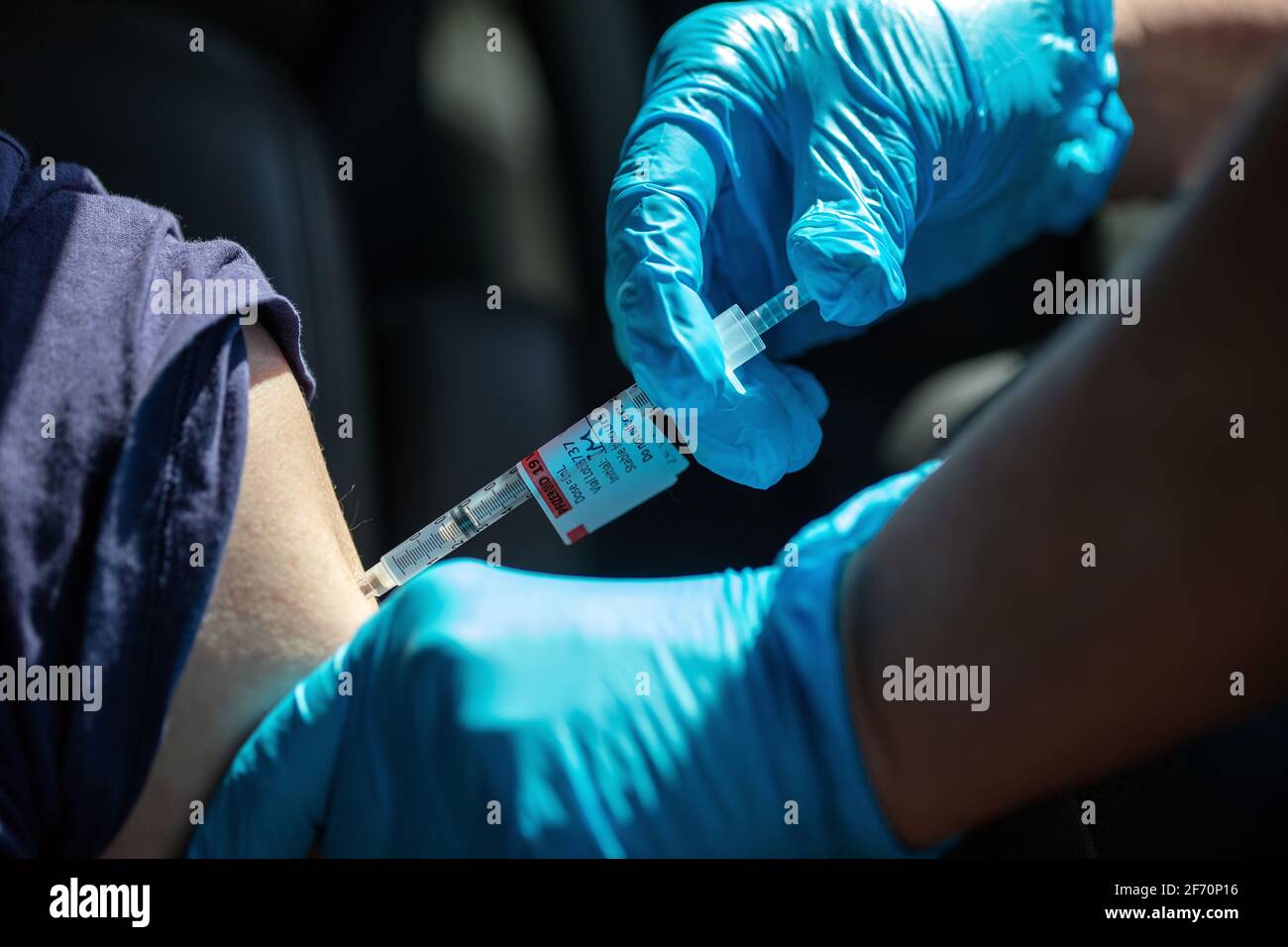 A woman receives a Covid-19 shot at a Sutter Health drive through vaccination site in Santa Cruz, California.  April 3, 2021 Stock Photo