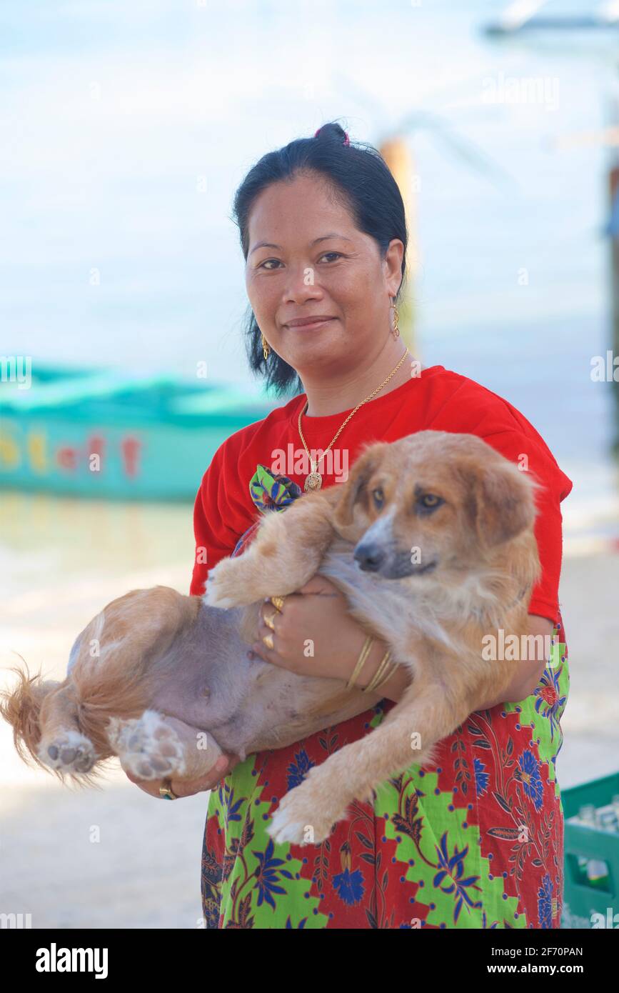 Filipina woman with her pet dog. Logon, Malapascua Island, Cebu, Philippines Stock Photo