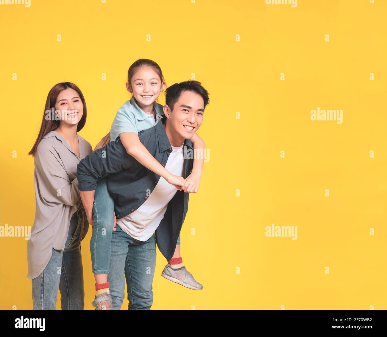 Happy Asian young family with one child standing embracing and smiling Stock Photo
