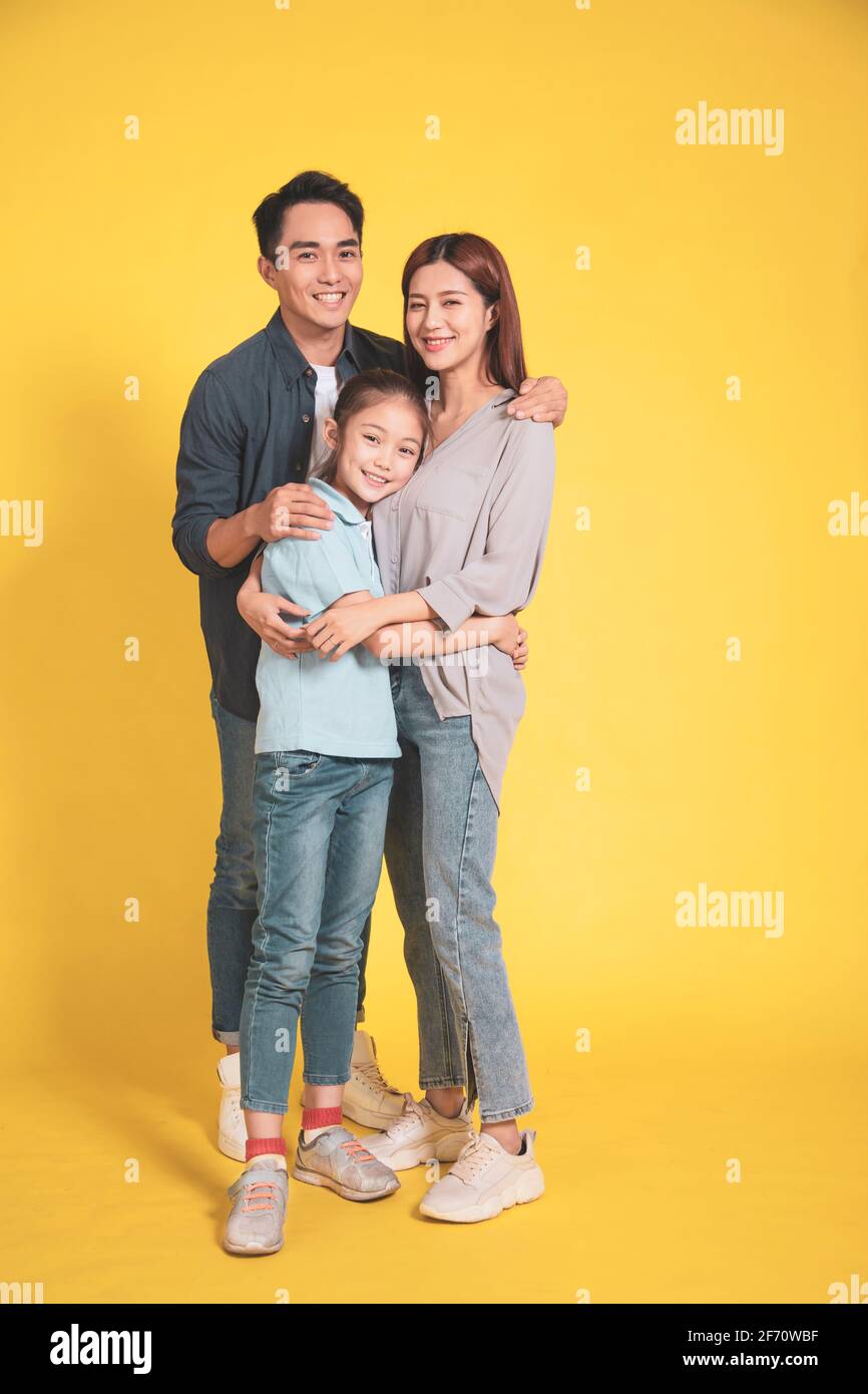 Happy Asian young family with one child standing embracing and smiling Stock Photo