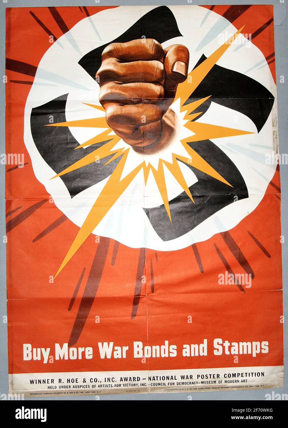 A second world war poster showing a fist breaking a swastika, asking people to buy war bonds and stamps Stock Photo