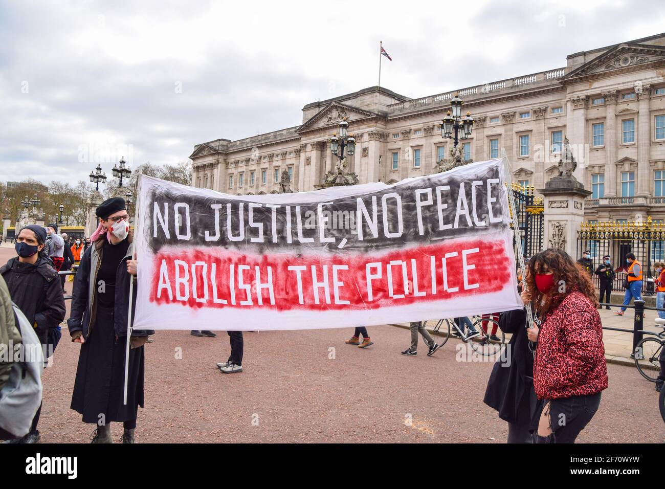 Protesters hold a banner saying No Justice, No Peace, Abolish The Police during the Kill The Bill march outside Buckingham Palace.Thousands of people marched through Central London to protest against the Police, Crime, Sentencing and Courts Bill. Stock Photo