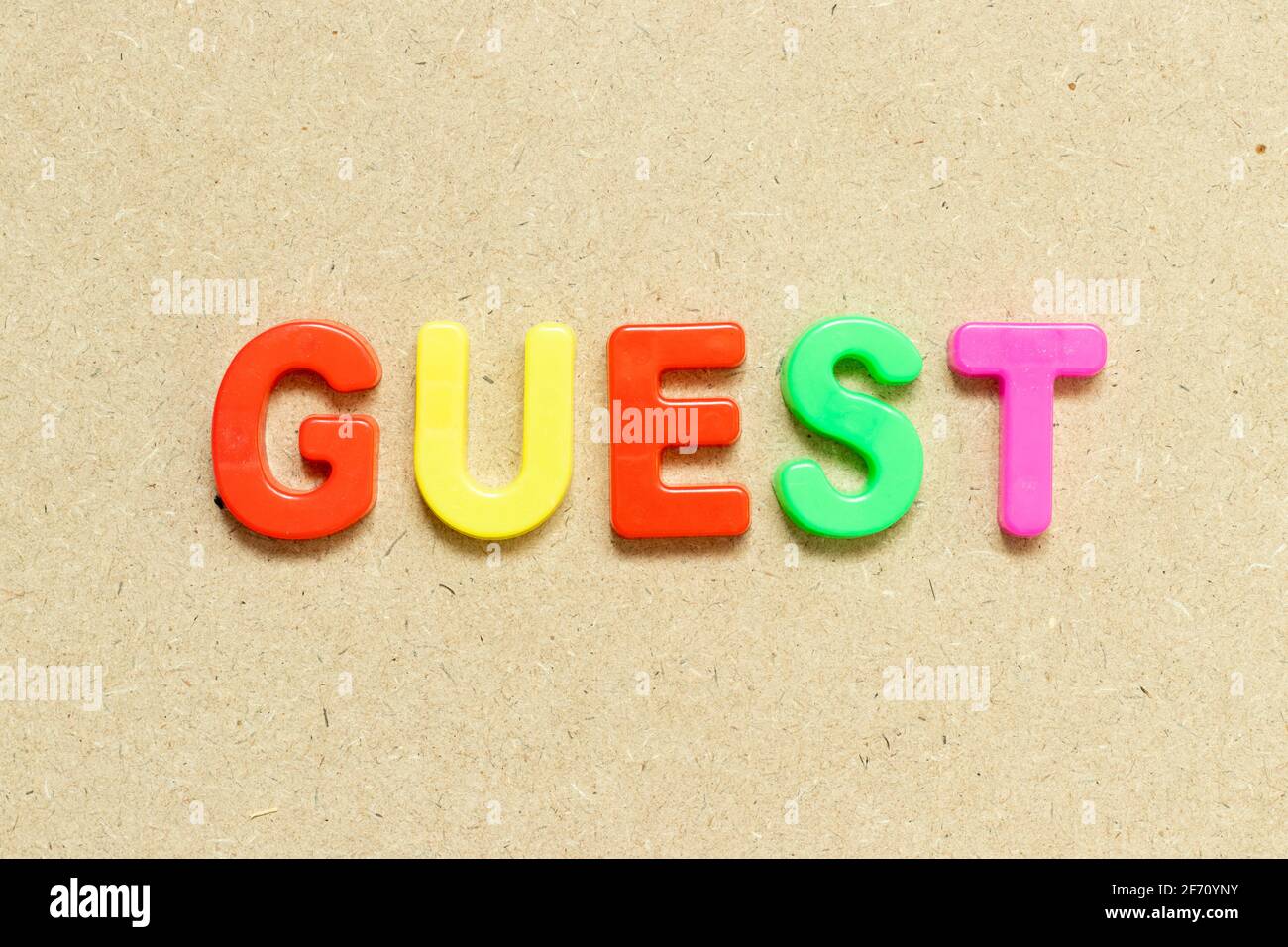 color-alphabet-letter-with-word-guest-on-wood-background-stock-photo