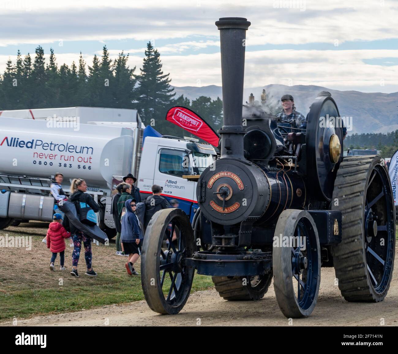 Wanaka, New Zealand, 3 April, 2021. An 1896 steam traction tractor manufactured by John Fowler & Company in Leeds, England,  passes a petrol tanker it will never need at the 'Wheels at Wanaka' annual motoring festival. The event features hundreds of vintage and modern vehicles of all genres including vintage cars, tractors, trucks to earth moving and farming equipment which sees thousands of visitors over the three day event in this lakeside central Otago town, a popular tourist destination throughout the year.  Credit: Rob Taggart/Alamy Live News Stock Photo