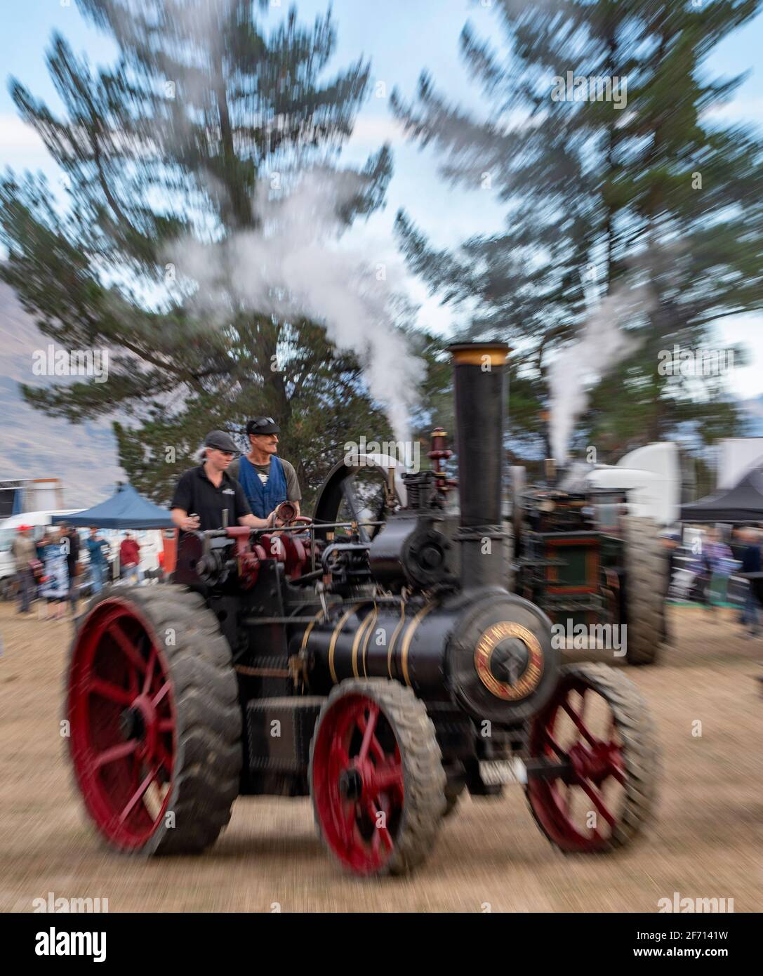 Wanaka, New Zealand, 3 April, 2021. A vintage steam traction tractor, manufactured by J & H McLaren in Leeds, England, in the late 19th century, steams past similar vehicles  at the 'Wheels at Wanaka' annual motoring festival. The event features hundreds of vintage and modern vehicles of all genres including vintage cars, tractors, trucks to earth moving and farming equipment which sees thousands of visitors over the three day event in this lakeside central Otago town, a popular tourist destination throughout the year. Credit: Rob Taggart/Alamy Live News Stock Photo