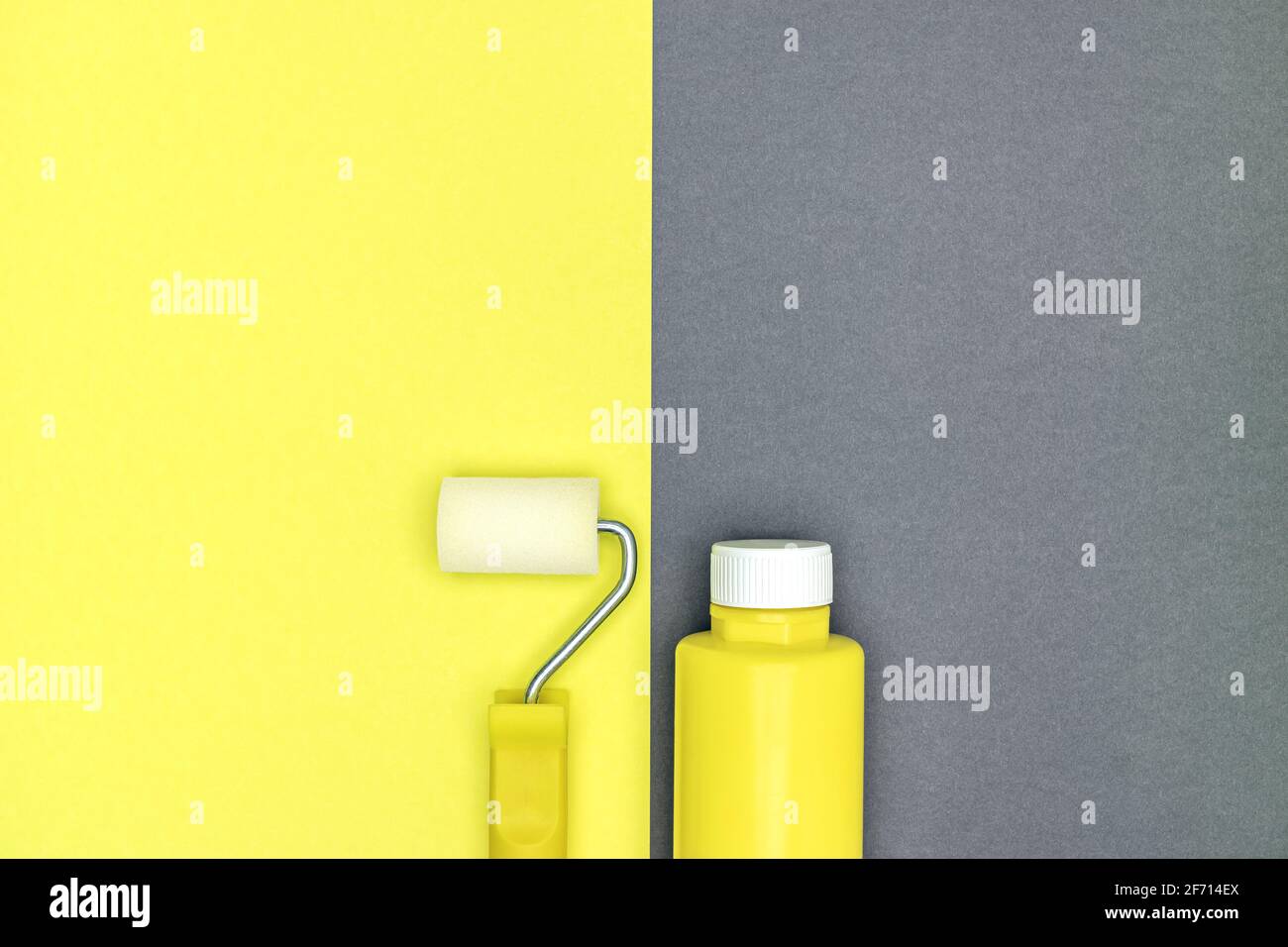 paint roller and bottle with colorful pigment on yellow and gray background. house renovation. Stock Photo