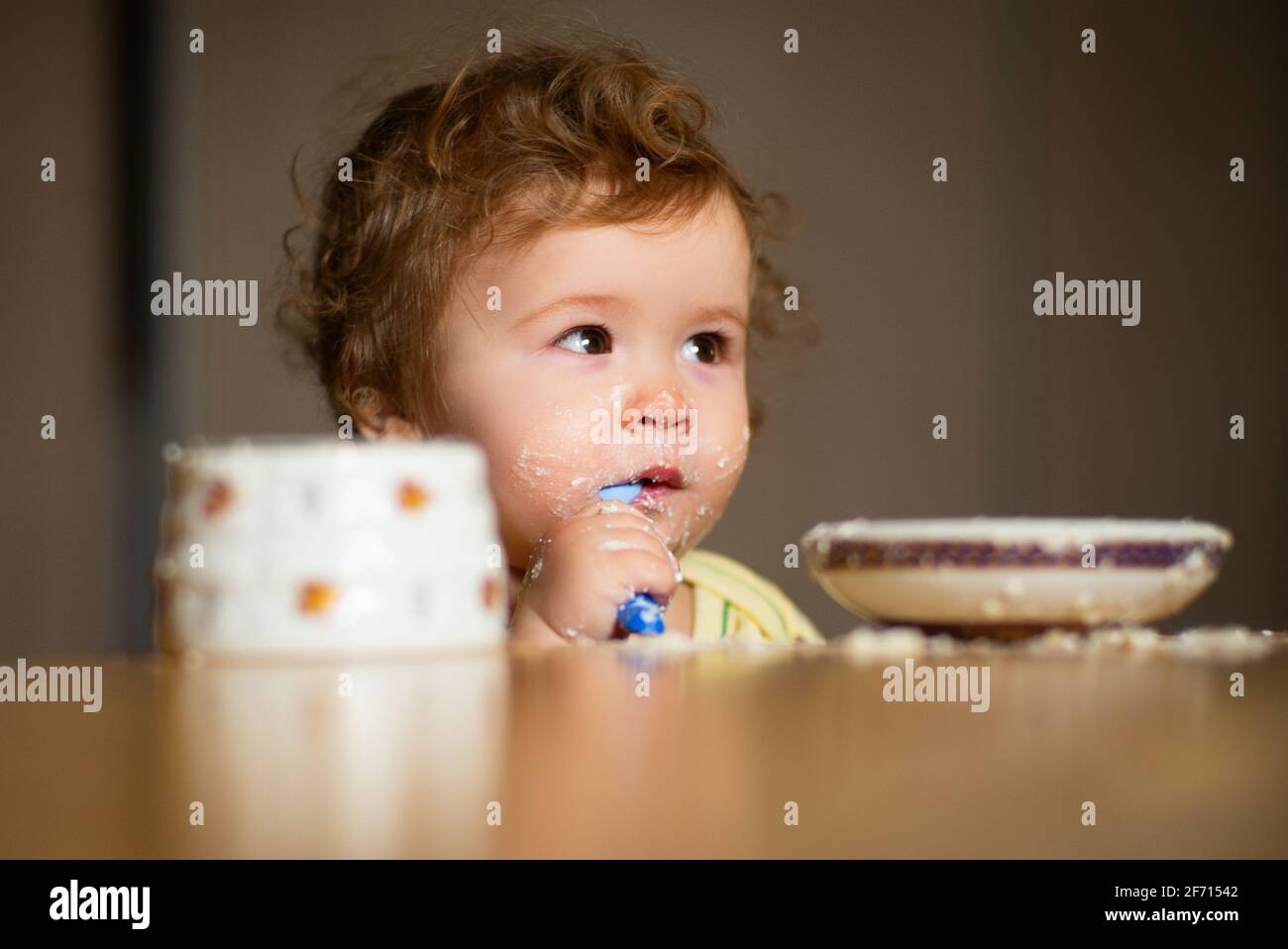 Child eating, nutrition concept. A baby eating food from a bowl. Stock Photo