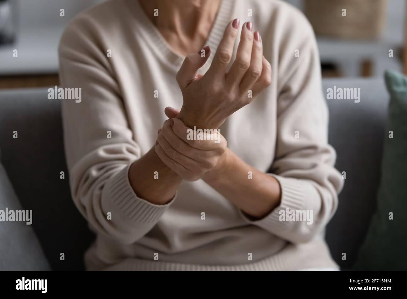 Middle aged elderly woman feeling wrist pain Stock Photo
