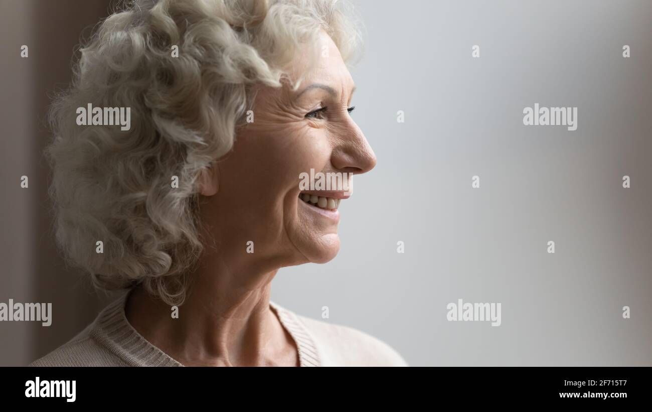 Side view portrait of happy old 70s woman looking away Stock Photo