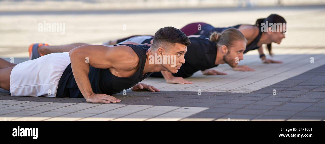 Group of fitness people doing push ups in the city Stock Photo - Alamy
