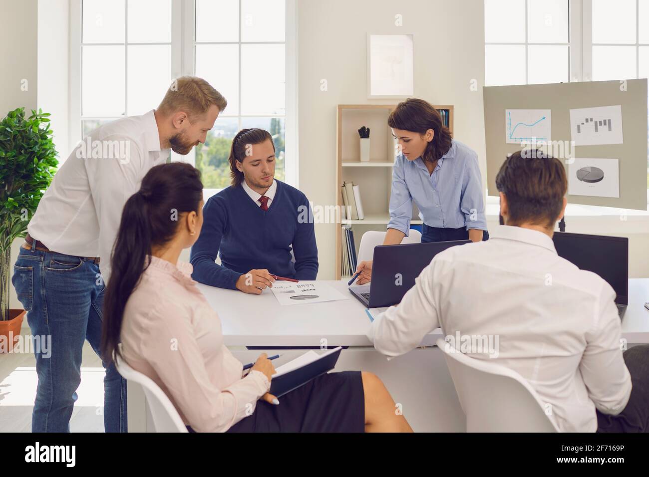Department manager holding meeting with employees and analyzing financial reports in modern office Stock Photo