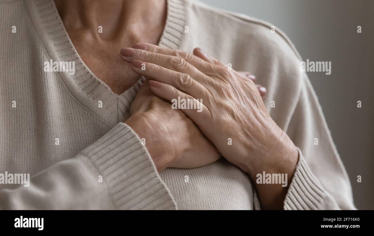 Mature elderly woman feeling heart pain, touching chest Stock Photo