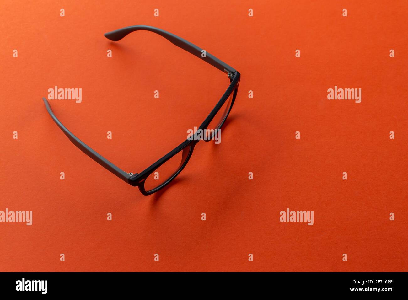 Eyeglasses on orange background, myopia or presbyopia.  Eyesight correction. Fashion accessories. Stock Photo