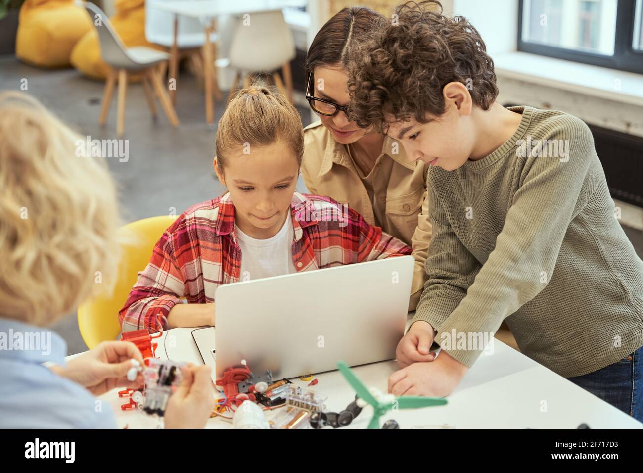 Computer science. Focused little kids learn programming using laptop ...