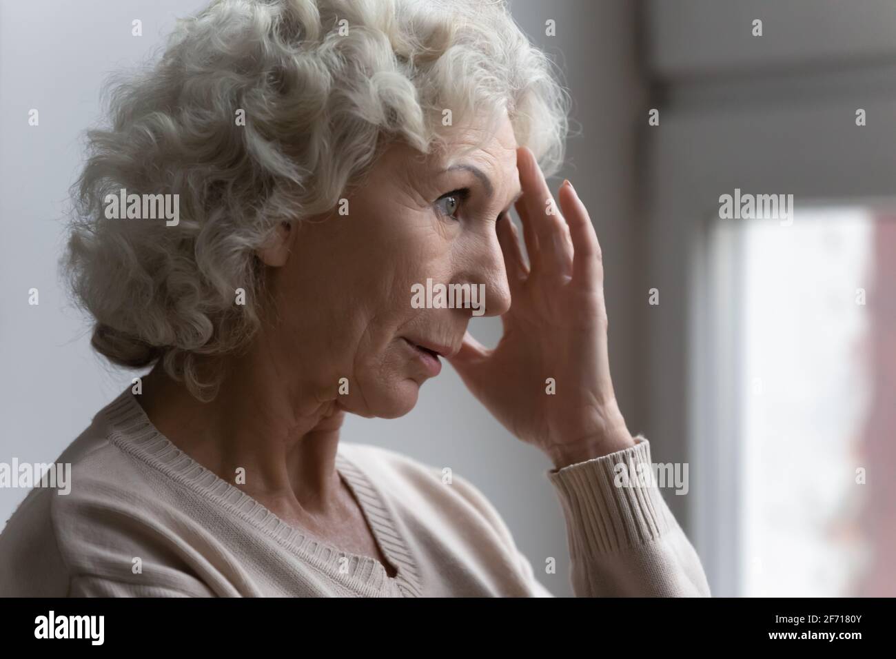 Confused worried old lady suffering from age disorders Stock Photo