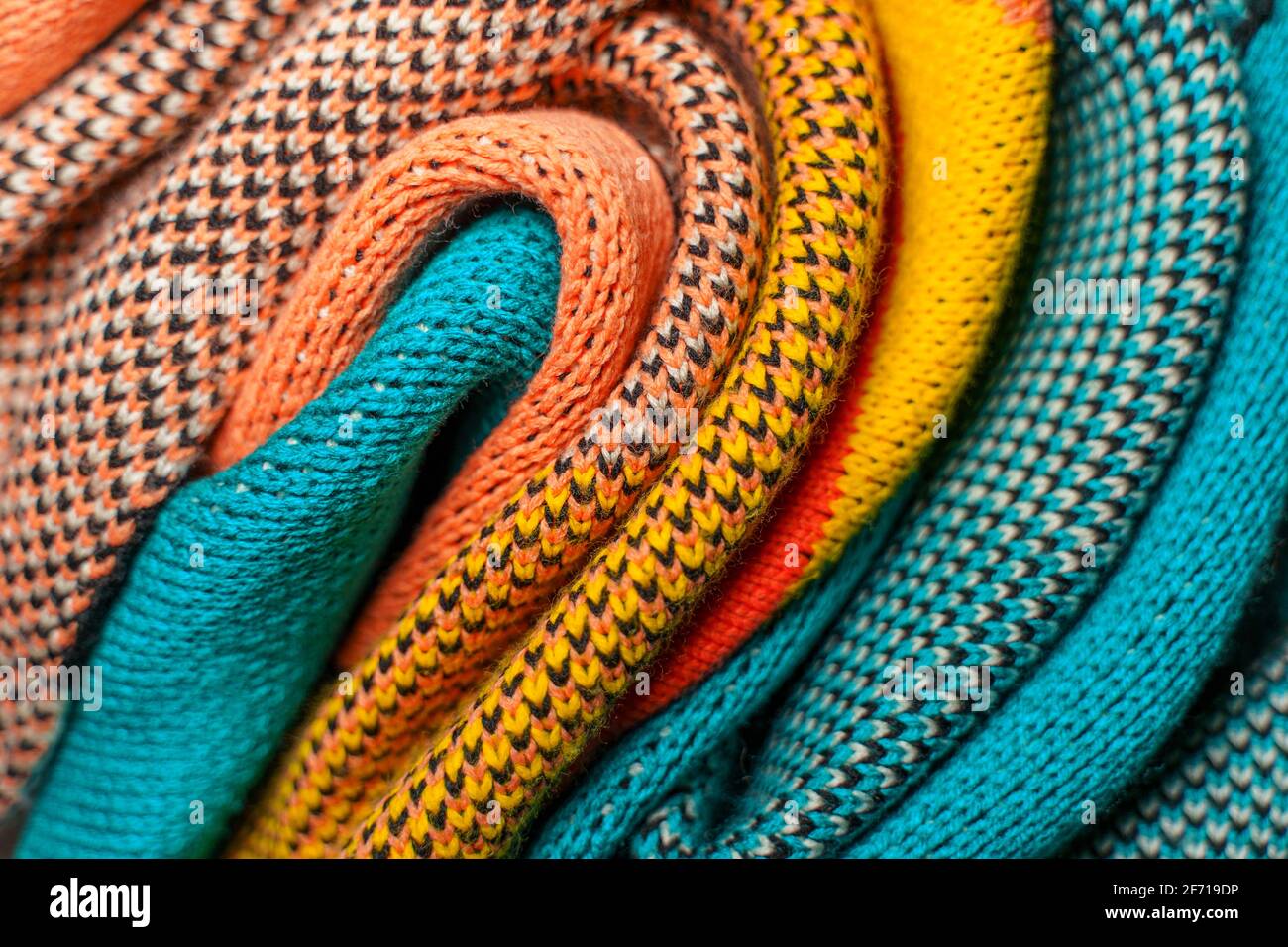 Twisted folds of colorful knitted fabrics of winter clothes with