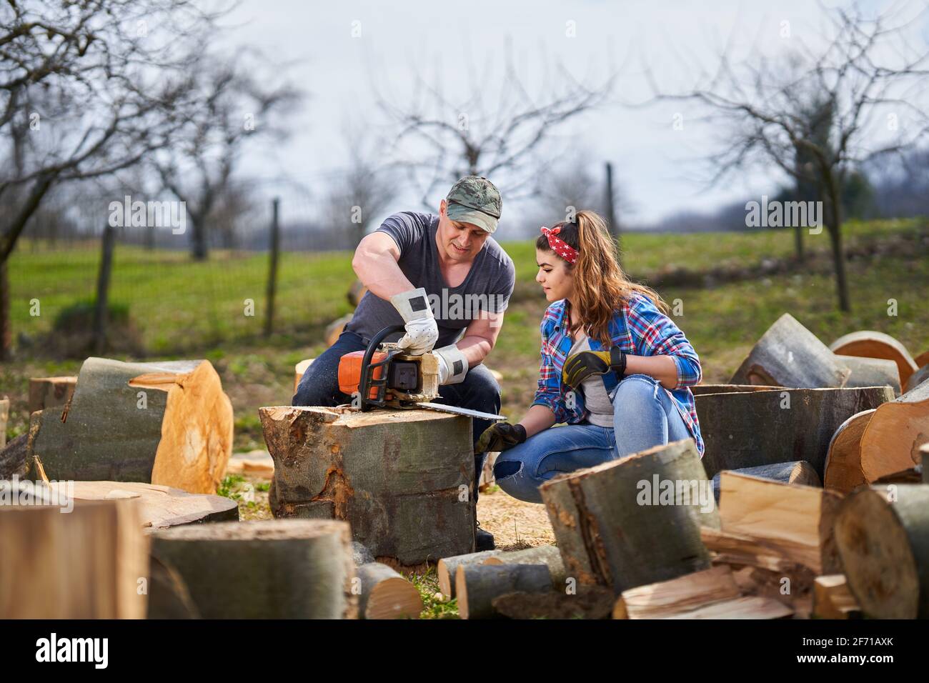 Lumberjack teaching his wife how to use the chainsaw Stock Photo Alamy