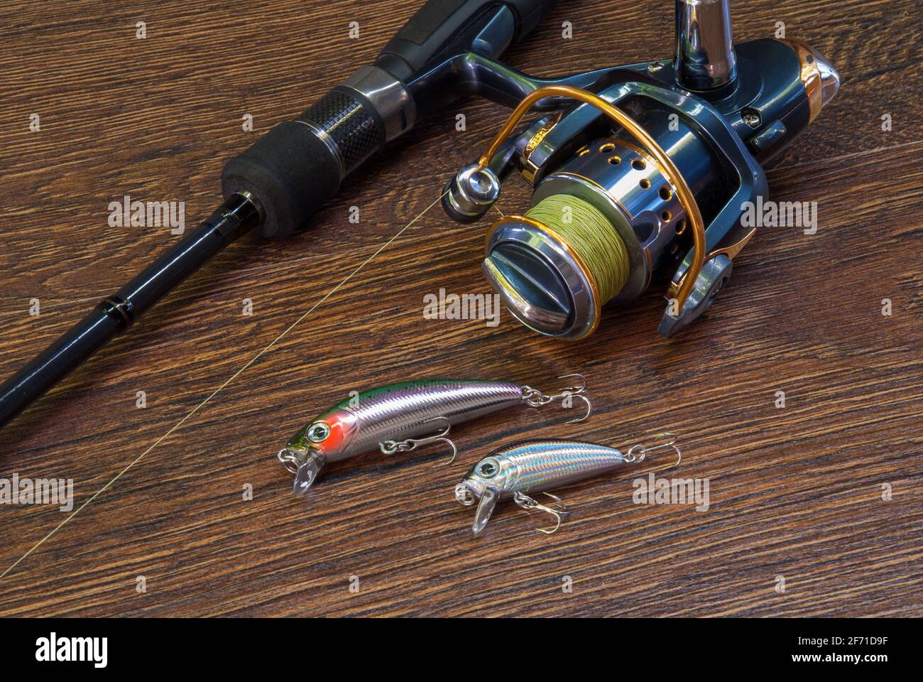 Fishing tackle. Hook, hat, fishing reel, lures on darken wooden background.  Still life Stock Photo