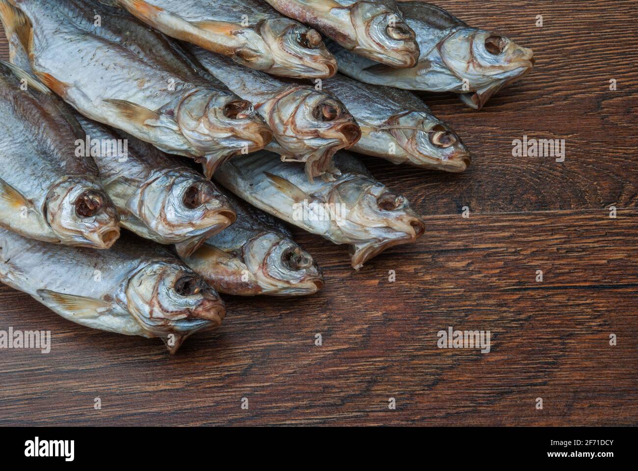 some dried fish on a dark wooden background Stock Photo - Alamy