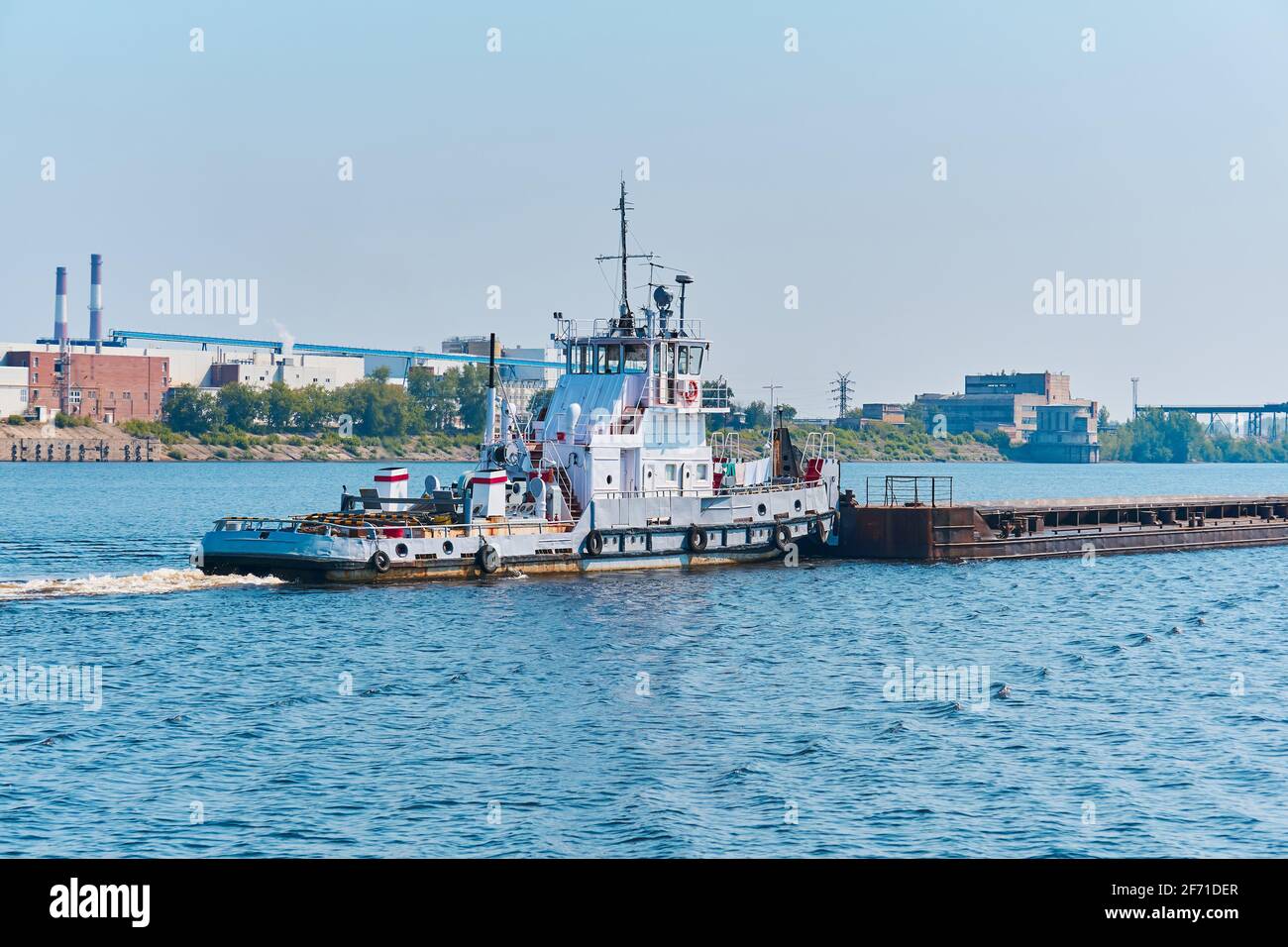 pusher boat pushes dry bulk cargo barge on the river in an industrial  landscape Stock Photo - Alamy