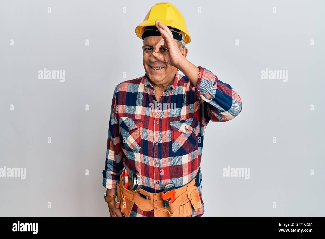 Senior hispanic man wearing handyman uniform doing ok gesture with hand ...
