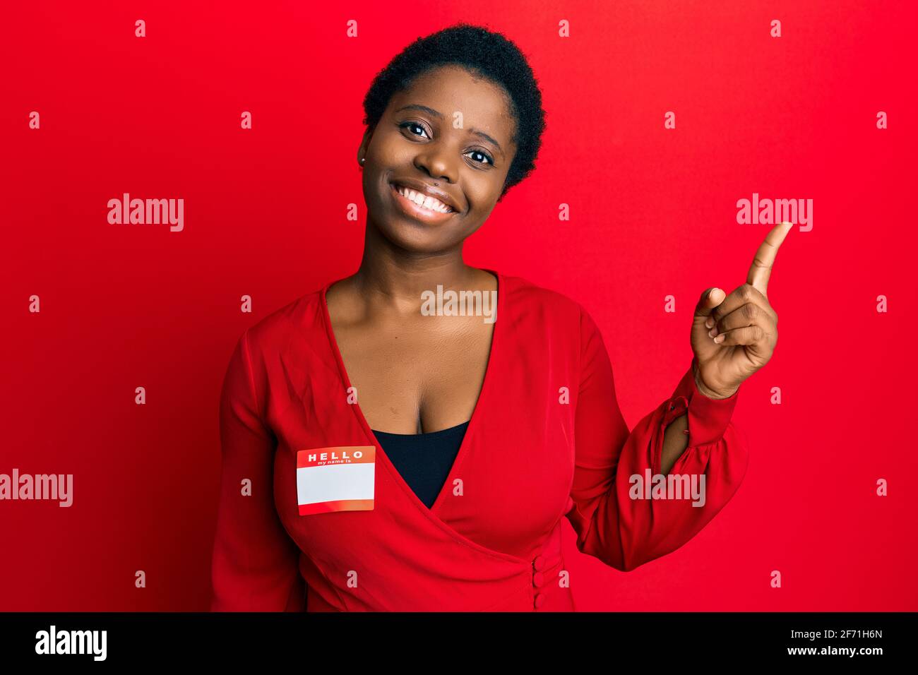 Young african woman with short hair wearing hello my name is sticker ...