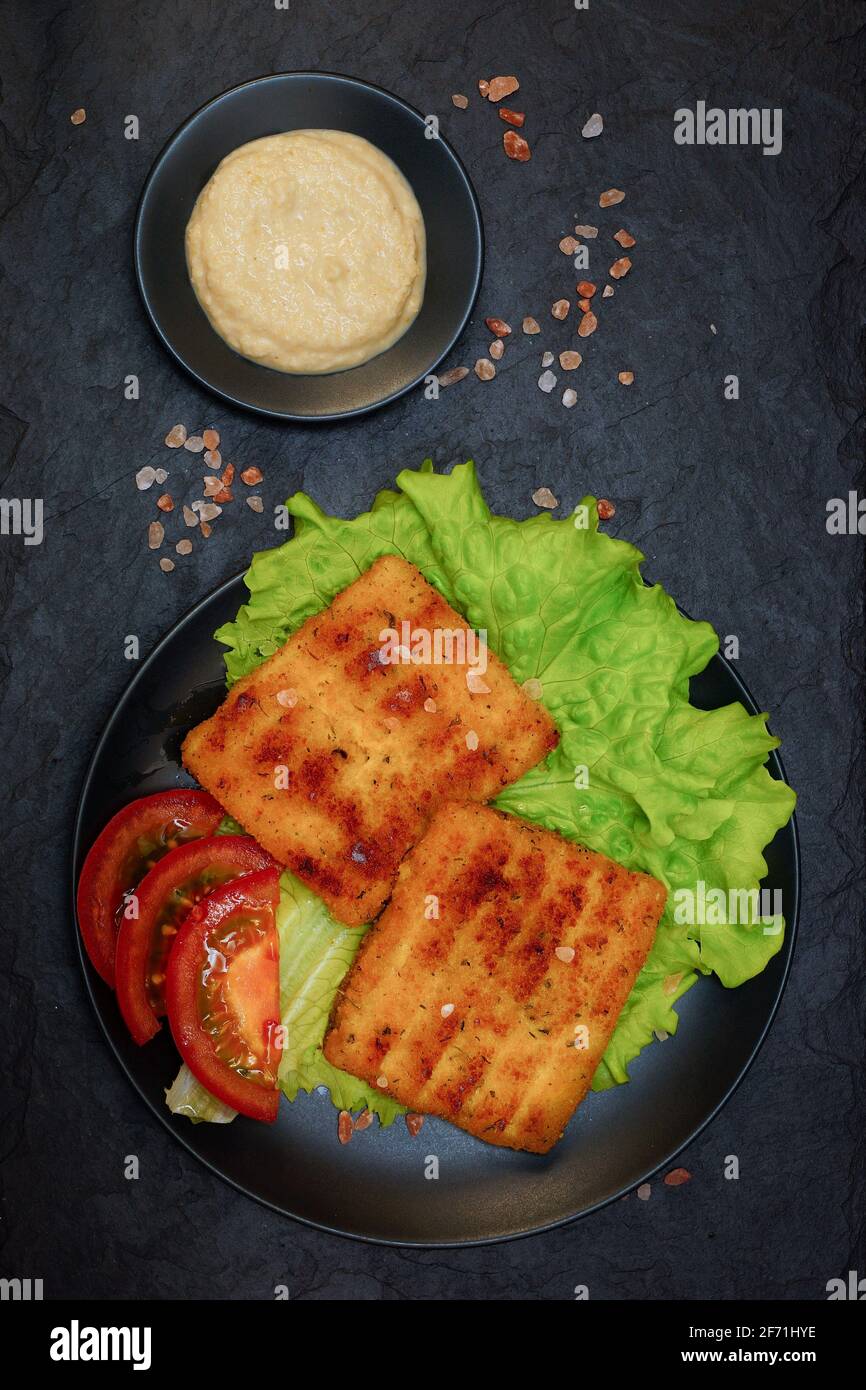 Deep-fried fish. Chunks of breaded fish fillets with horseradish on a ...