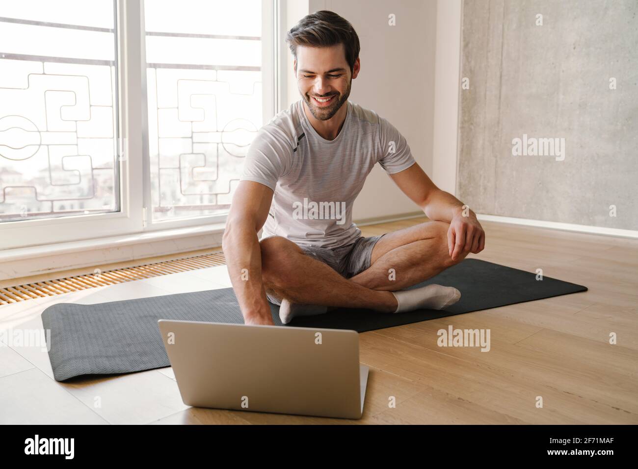 Person Working Out While Using Computer Happy athletic handsome man using laptop while working out at home ...