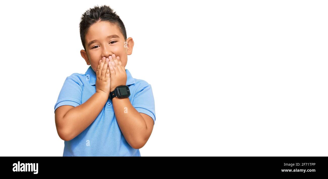 Little boy hispanic kid wearing casual clothes laughing and embarrassed giggle covering mouth with hands, gossip and scandal concept Stock Photo