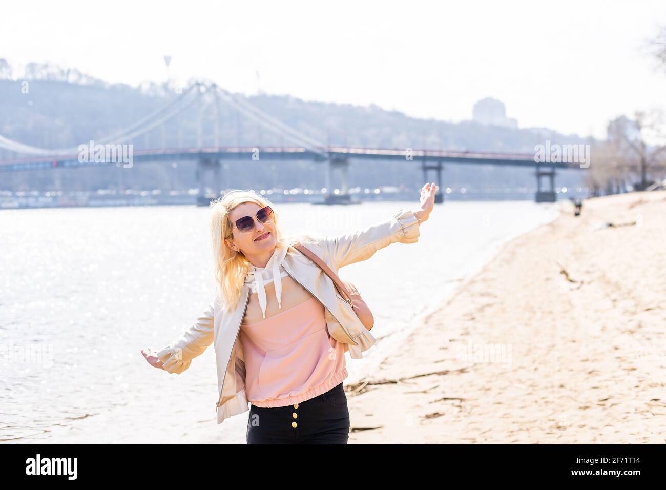 young woman raising arms up towards blue sky and river Stock Photo - Alamy